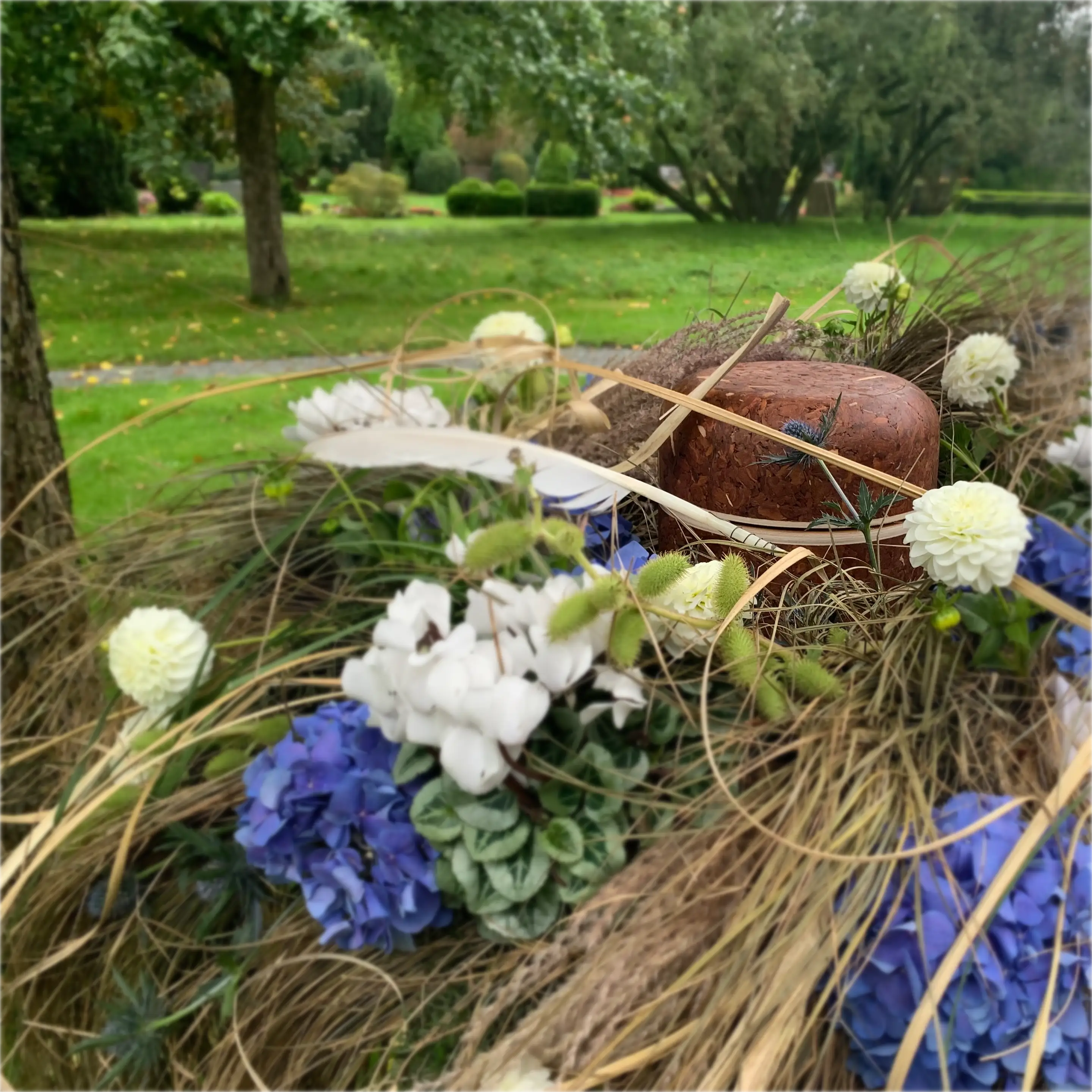 Dekorierte Urne vor der Beisetzung auf dem Friedhof